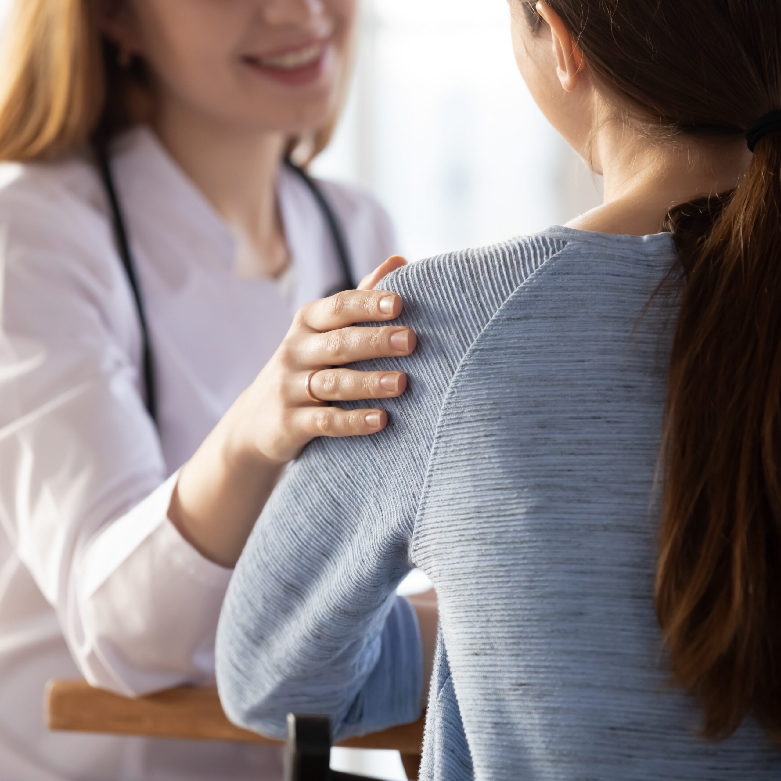 Close Up Of Female Doctor Support Patient At Consultation